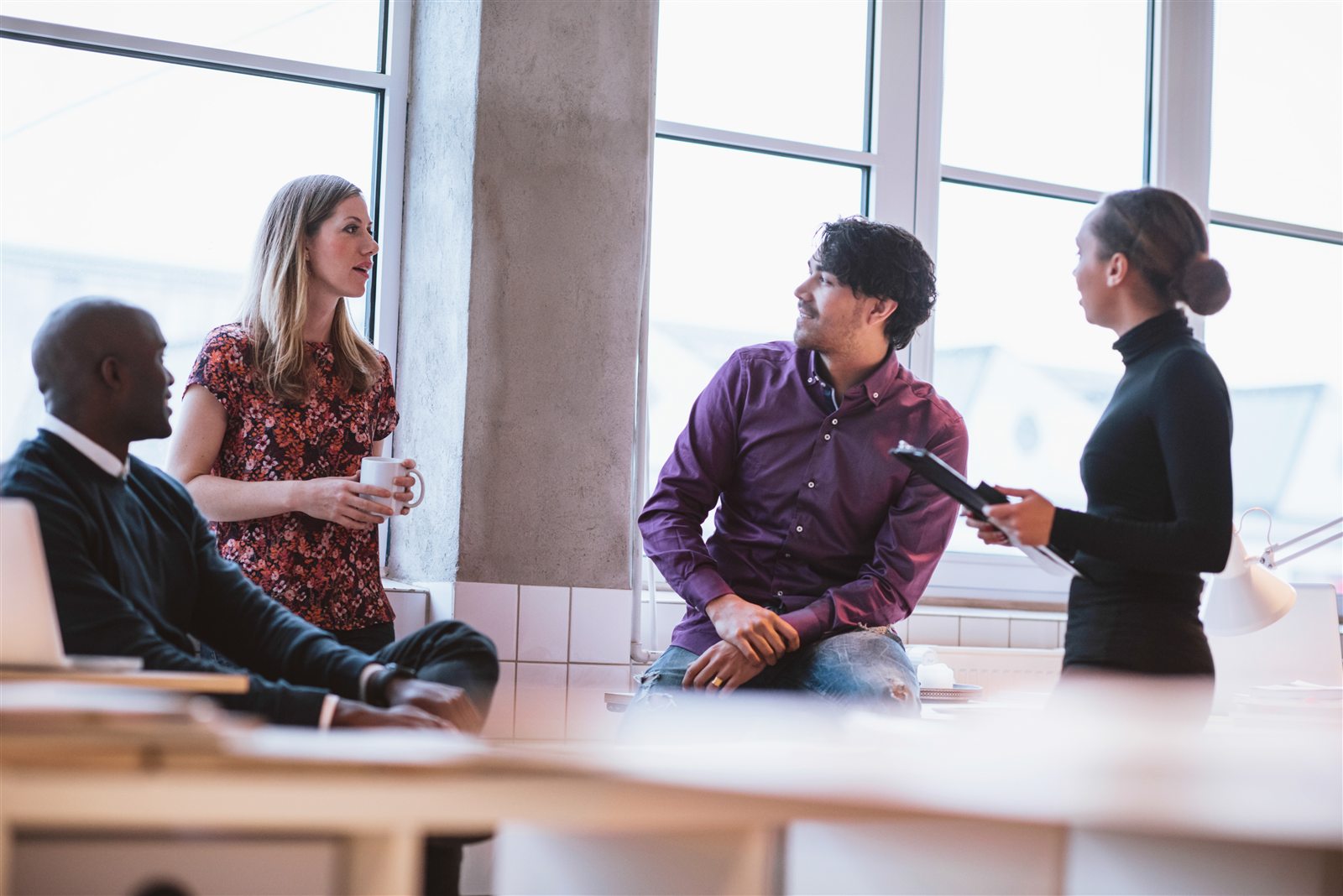Professionals discussing work together in a bright office.